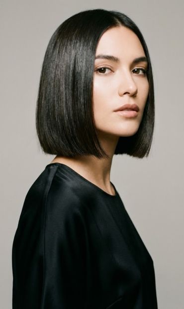 Mujer con corte de pelo bob recto y cabello oscuro liso, vistiendo blusa negra