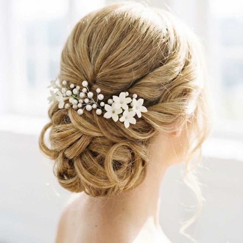 Elegante peinado recogido con flores blancas y perlas para boda