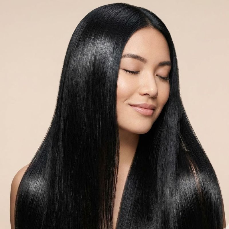 Mujer con cabello largo y liso, mostrando brillo y salud capilar.